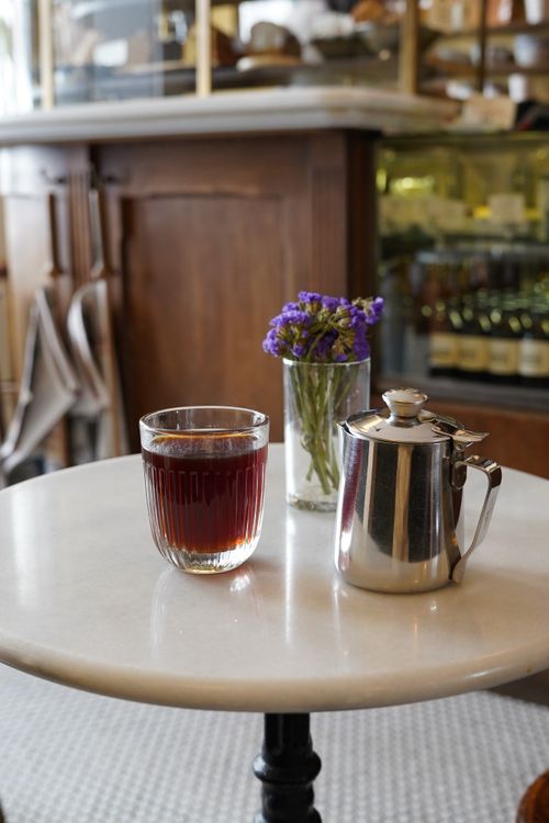 Free Stylish coffee setup with a glass and pot on a marble table, perfect for a cozy brunch setting. Stock Photo