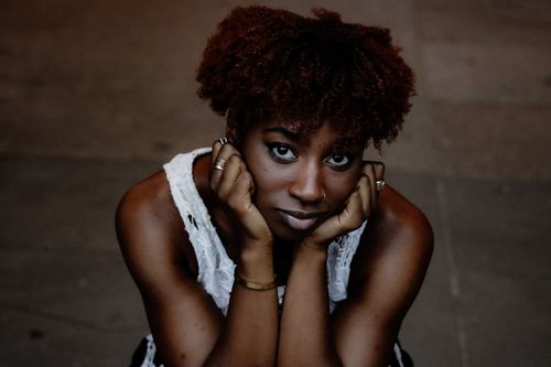 Free Striking portrait of a woman with curly hair, contemplative pose in Berlin. Stock Photo