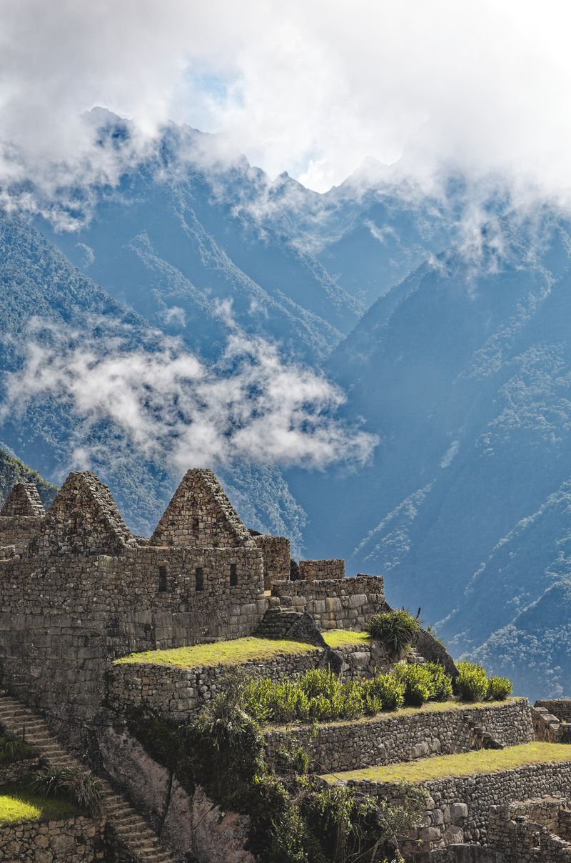 Construcciones de piedra de Machu Picchu con bruma sobre las montañas andinas
