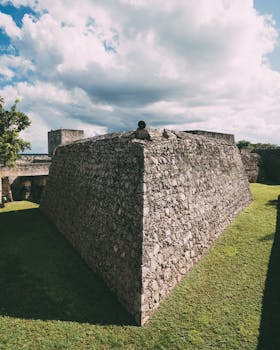 古老的石头堡垒有着厚厚的墙壁，在绿意环绕下映衬着明亮的天空