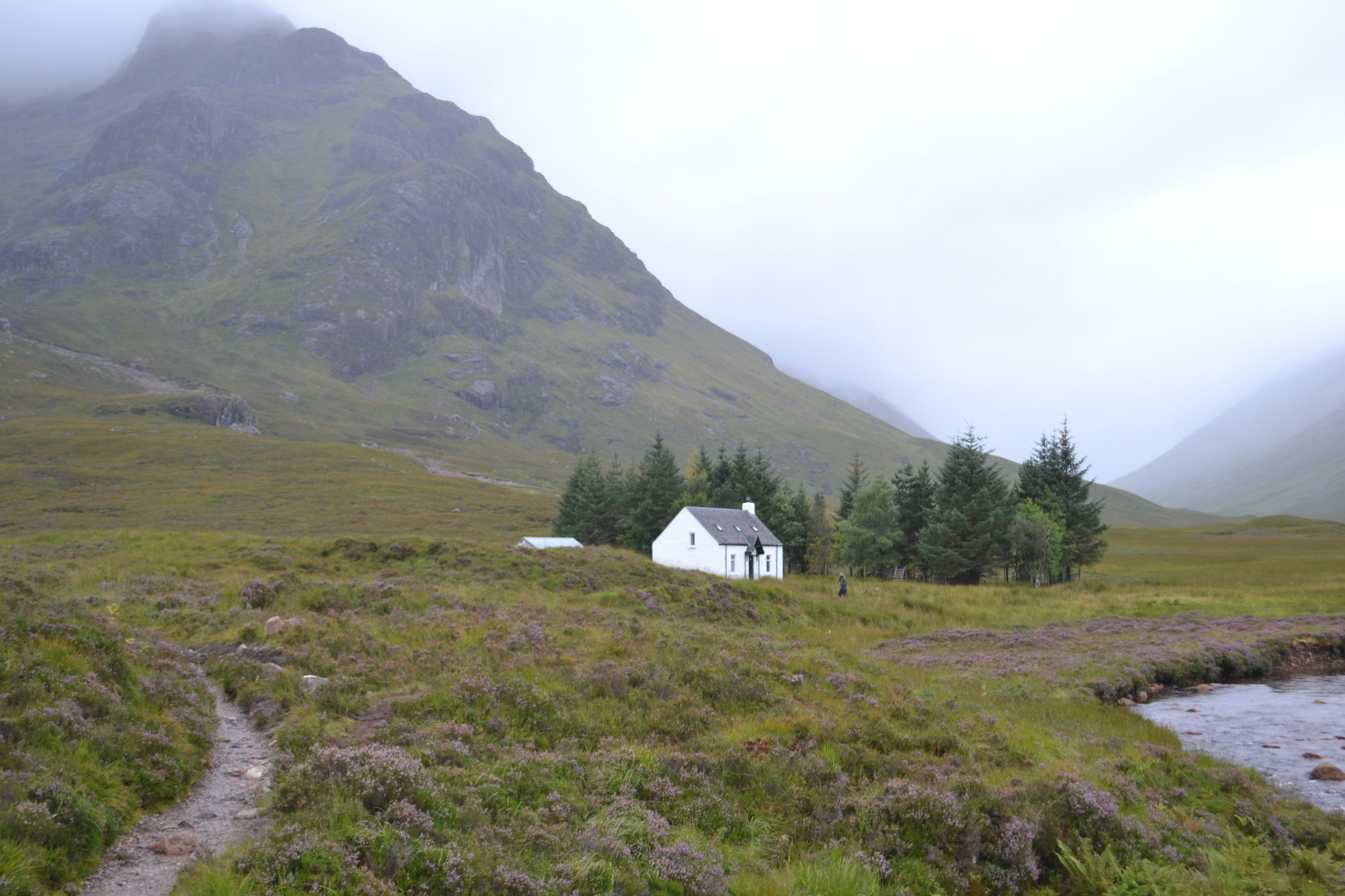 A small white house sits in the middle of a mountain · Free Stock Photo