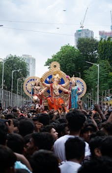 Crowd gathers to celebrate Ganesh Chaturthi in Mumbai, with a large Ganesha idol procession.