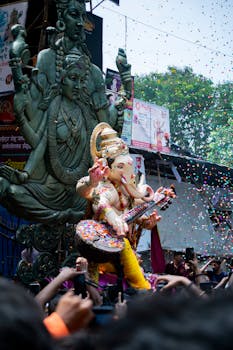 Colorful Ganesh Chaturthi festival with ornate statues and lively crowds in Mumbai streets.