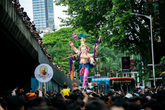 Vibrant Ganesh Chaturthi parade in Mumbai, showcasing a decorated Lord Ganesha idol amidst a lively crowd.