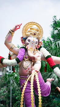Vibrant Ganesh idol adorned with gold and flowers during Ganesh Chaturthi festival in Mumbai, India.