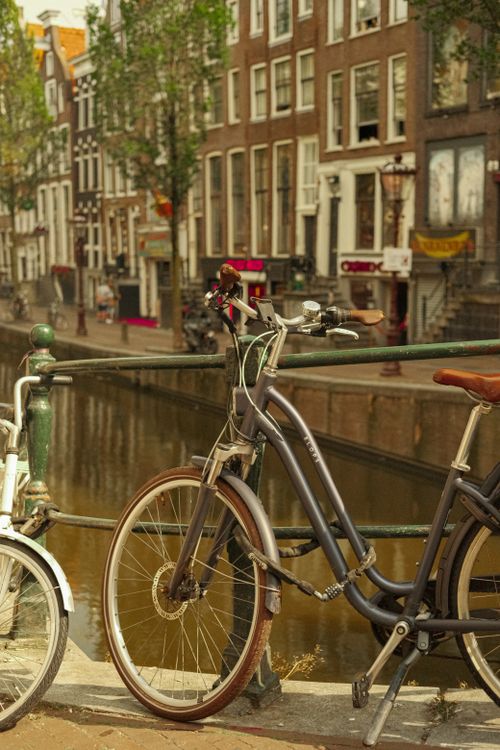 Free Classic cityscape featuring parked bicycles along a canal in an urban setting. Stock Photo