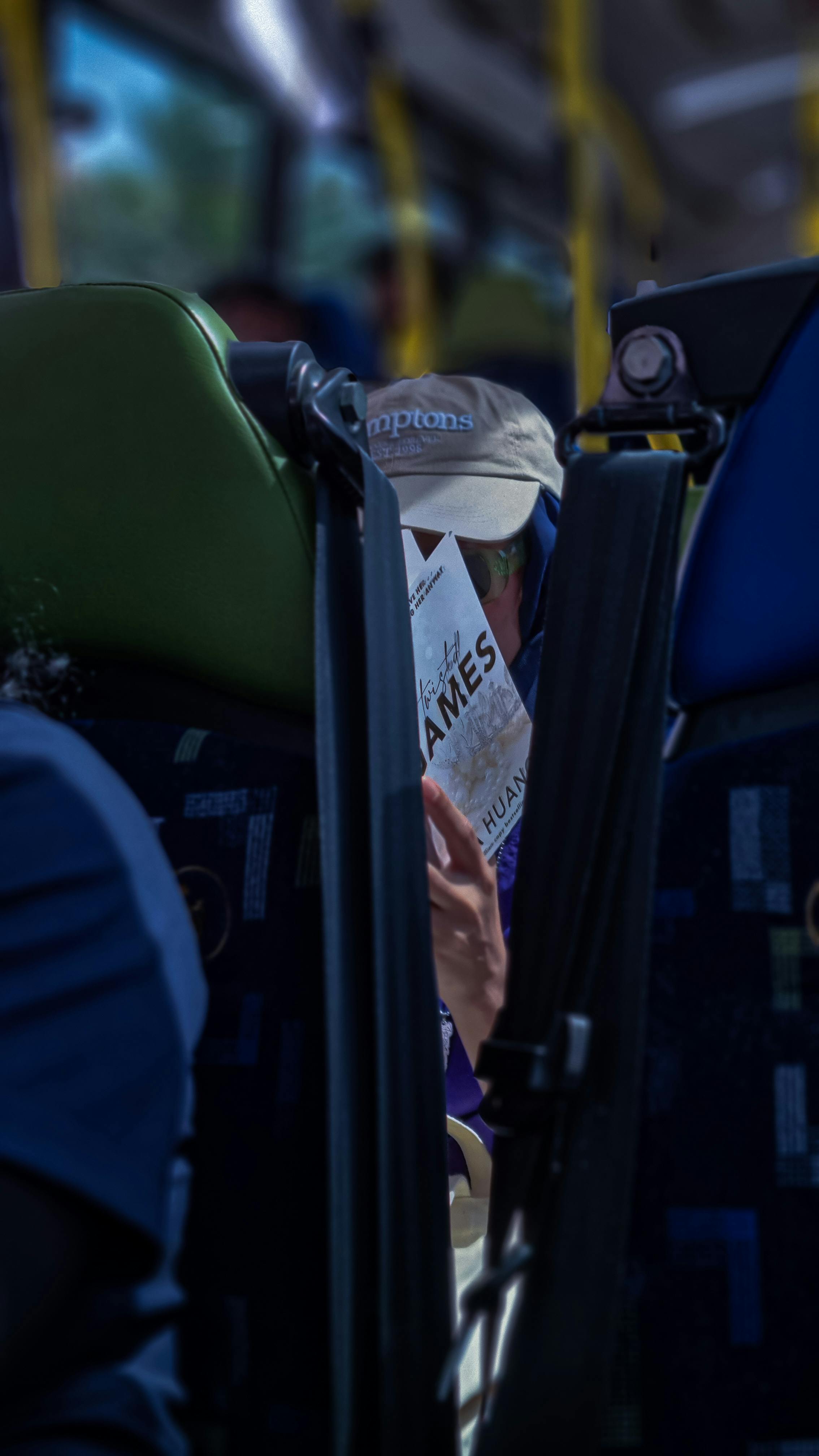 a man reading a newspaper on a bus