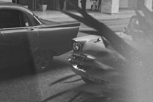 一辆经典古董车以单色风格停在街道上，勾起了人们的怀旧之情