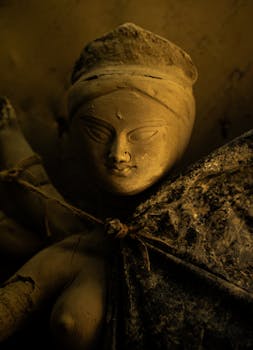 Ethereal clay sculpture of a woman, captured in warm, moody lighting.