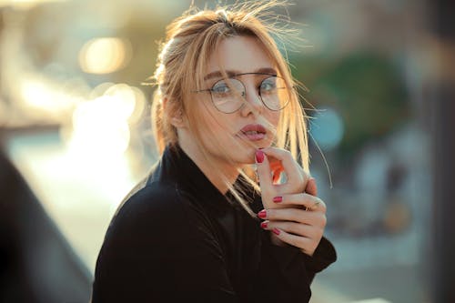 Free Woman Wears Eyeglasses and Touching Her Chin Stock Photo