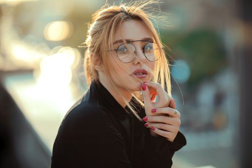 Free Portrait of a stylish woman wearing glasses, embracing natural light outdoors. Stock Photo