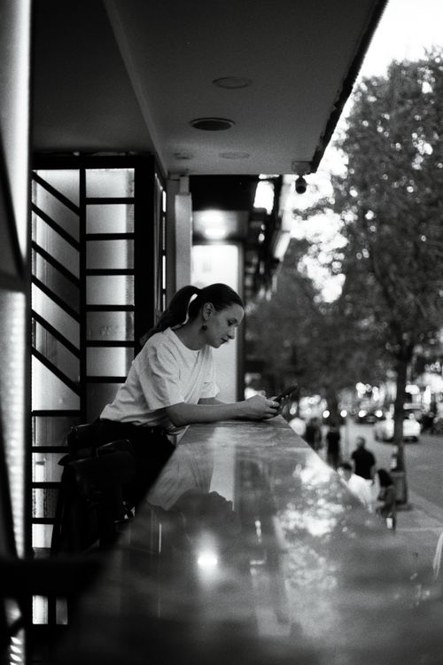 Free Artistic monochrome photo of a woman on a balcony in the city. Stock Photo