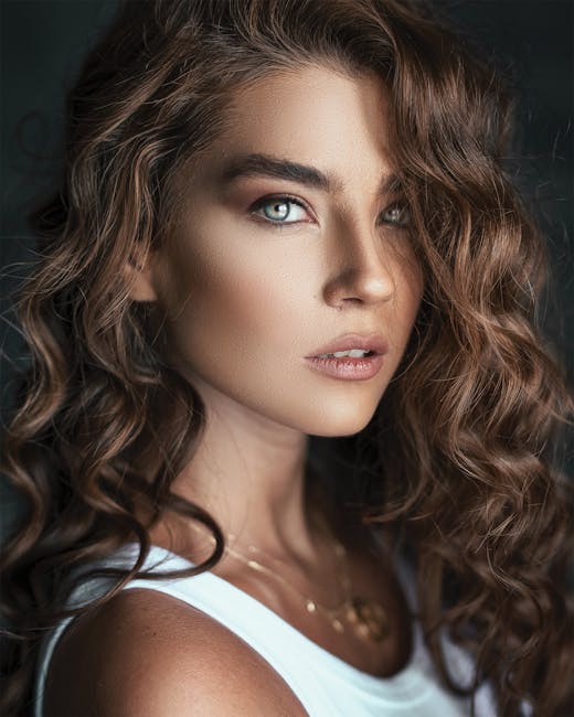 Captivating portrait of a woman with curly hair and striking eyes posing in natural light.