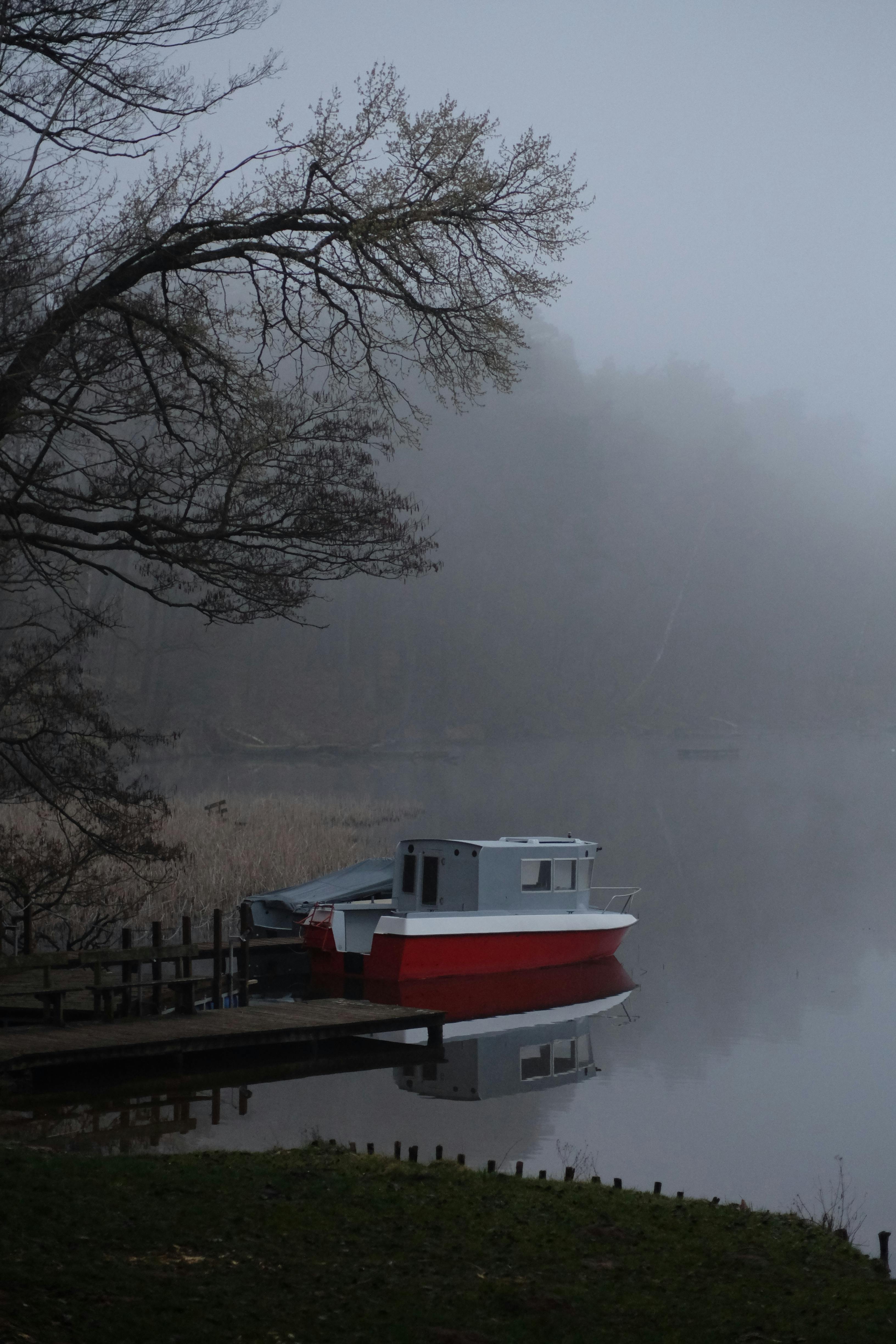 a boat is docked on the water in the fog