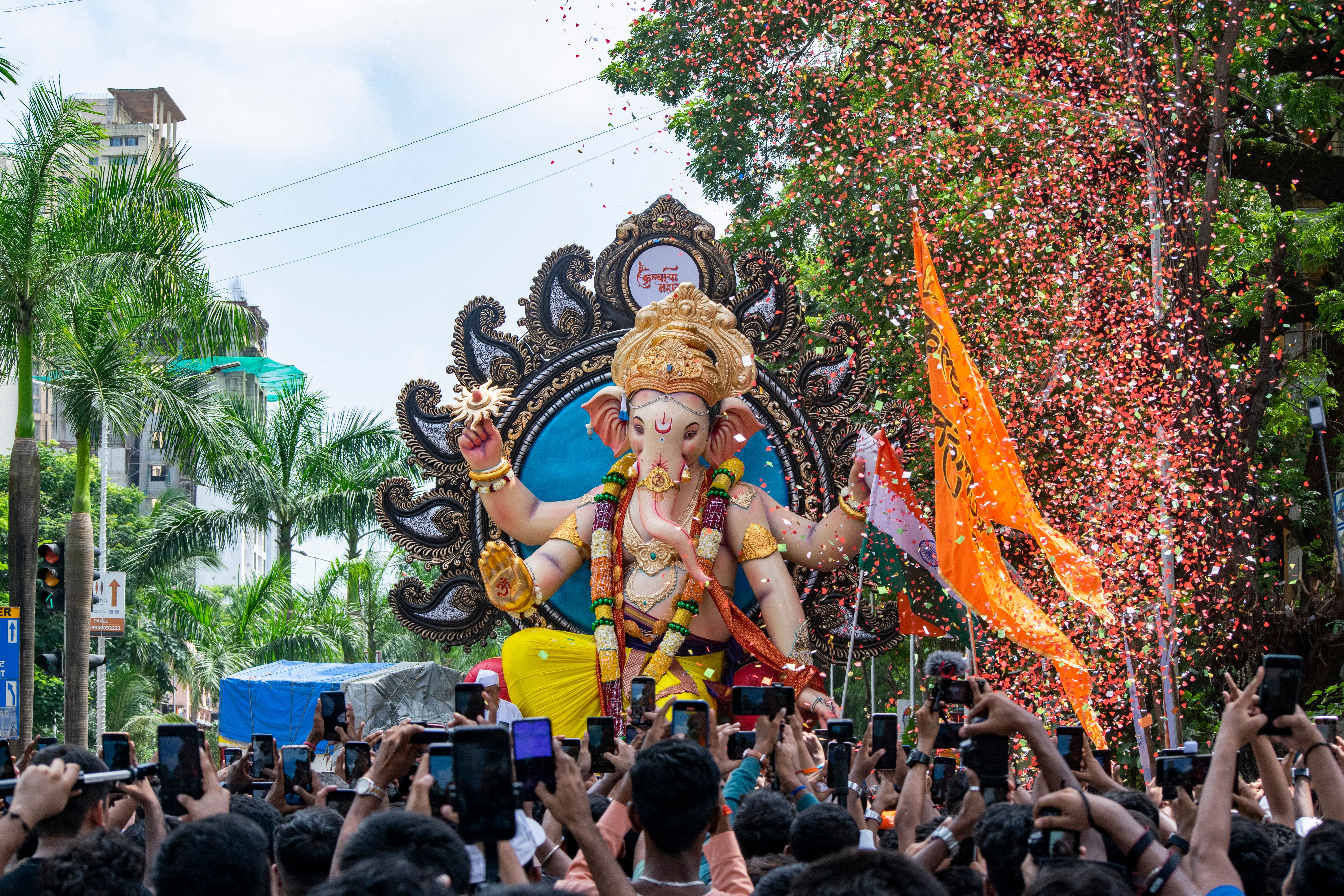 A Ganpati immersion procession moving through a crowded Mumbai street