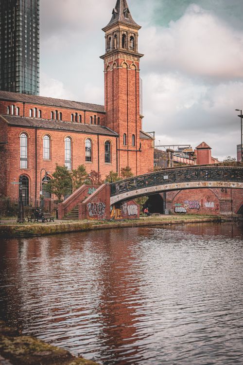 Free Scenic view of a historic brick building and canal bridge in Manchester, England. Stock Photo