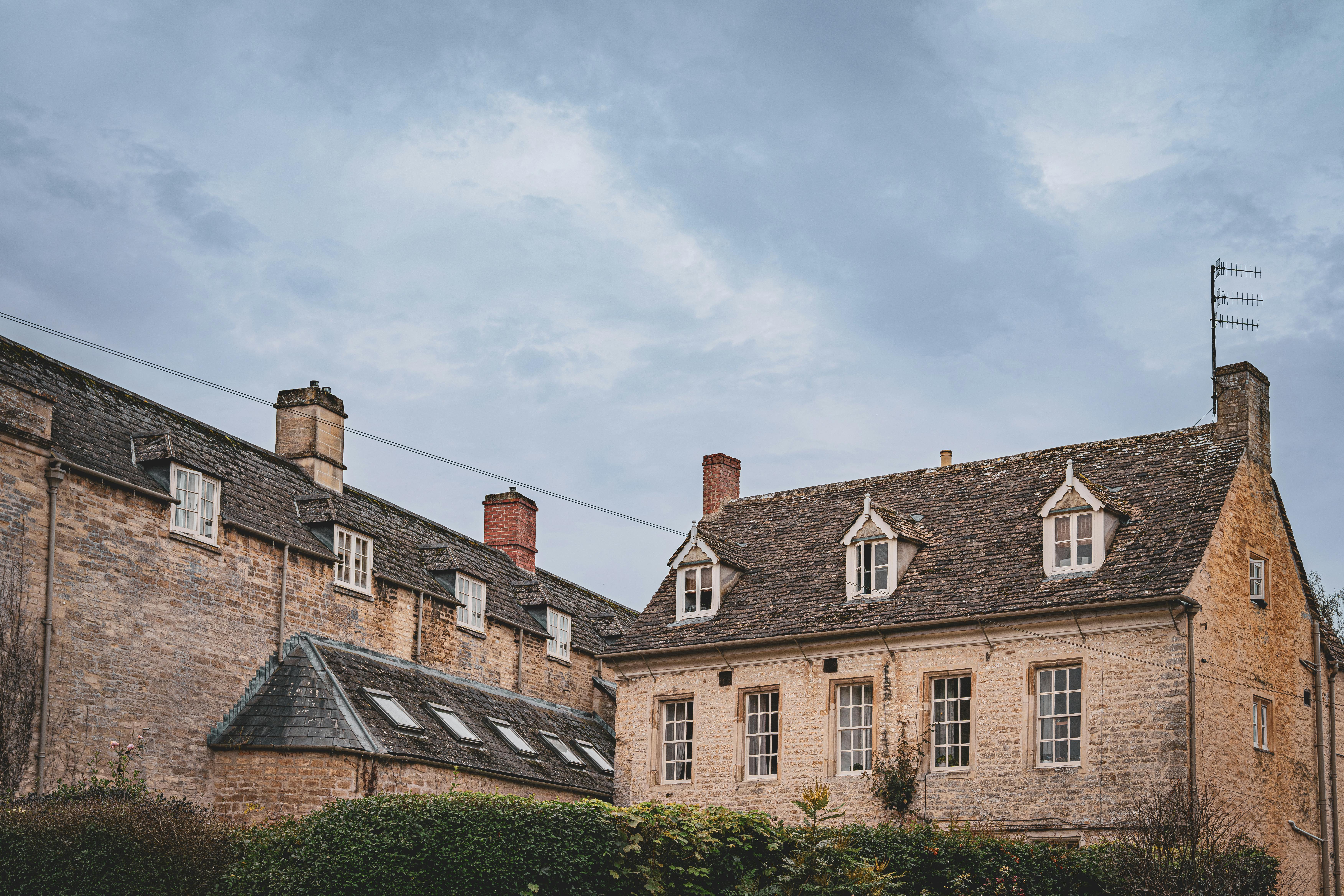 Traditional stone houses in the English countryside under a cloudy sky. - Manchester