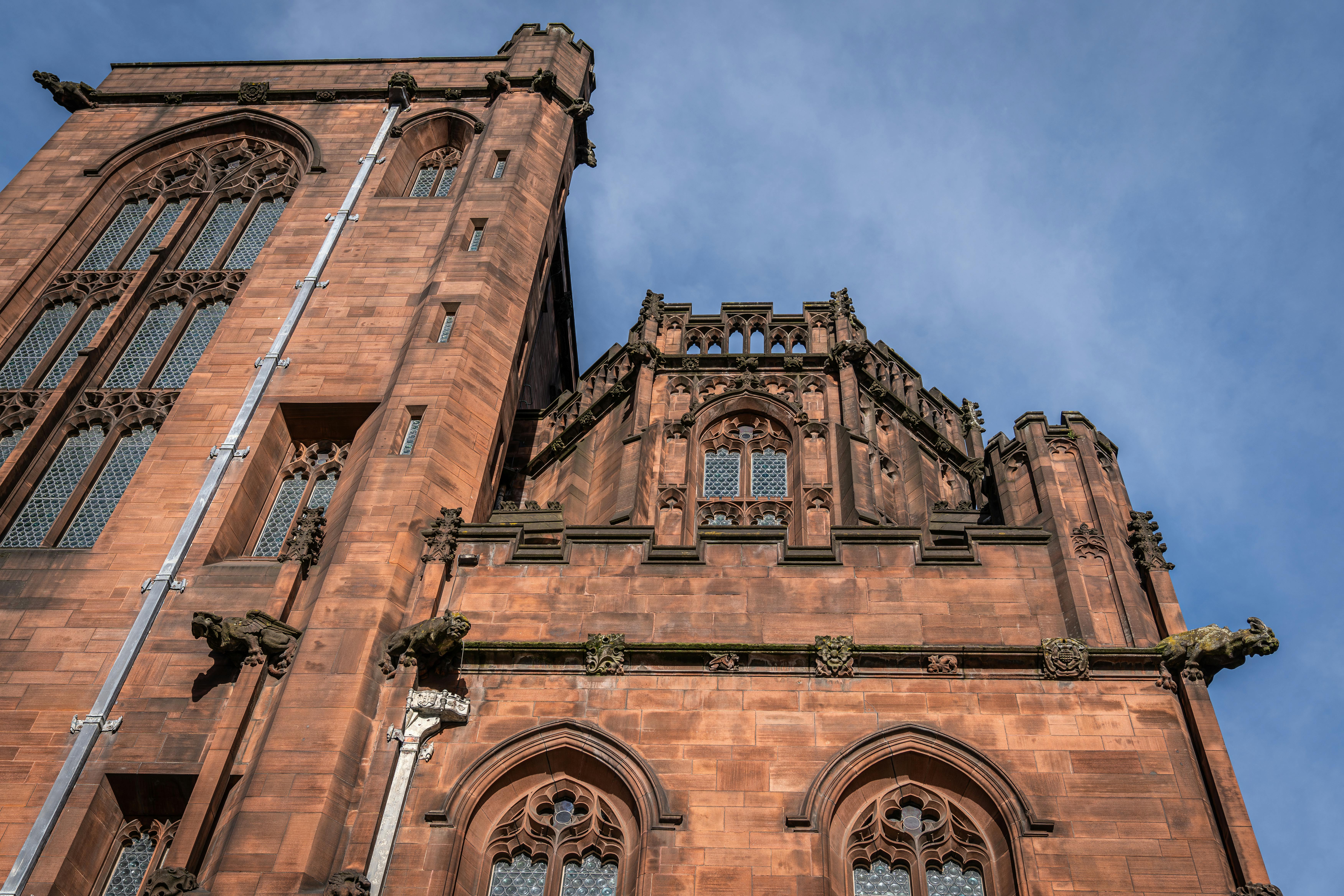 Detailed view of the Gothic architecture of Manchester Cathedral, emphasizing its intricate stonework and historic design. - Manchester