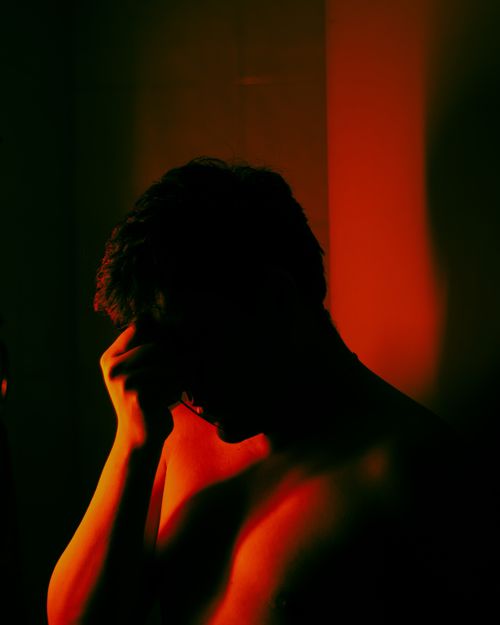 Free Silhouette of a man in dramatic red lighting, evoking introspection and emotion. Stock Photo