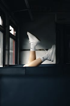 White sneakers and socks in a casual pose inside a train, urban vibe.