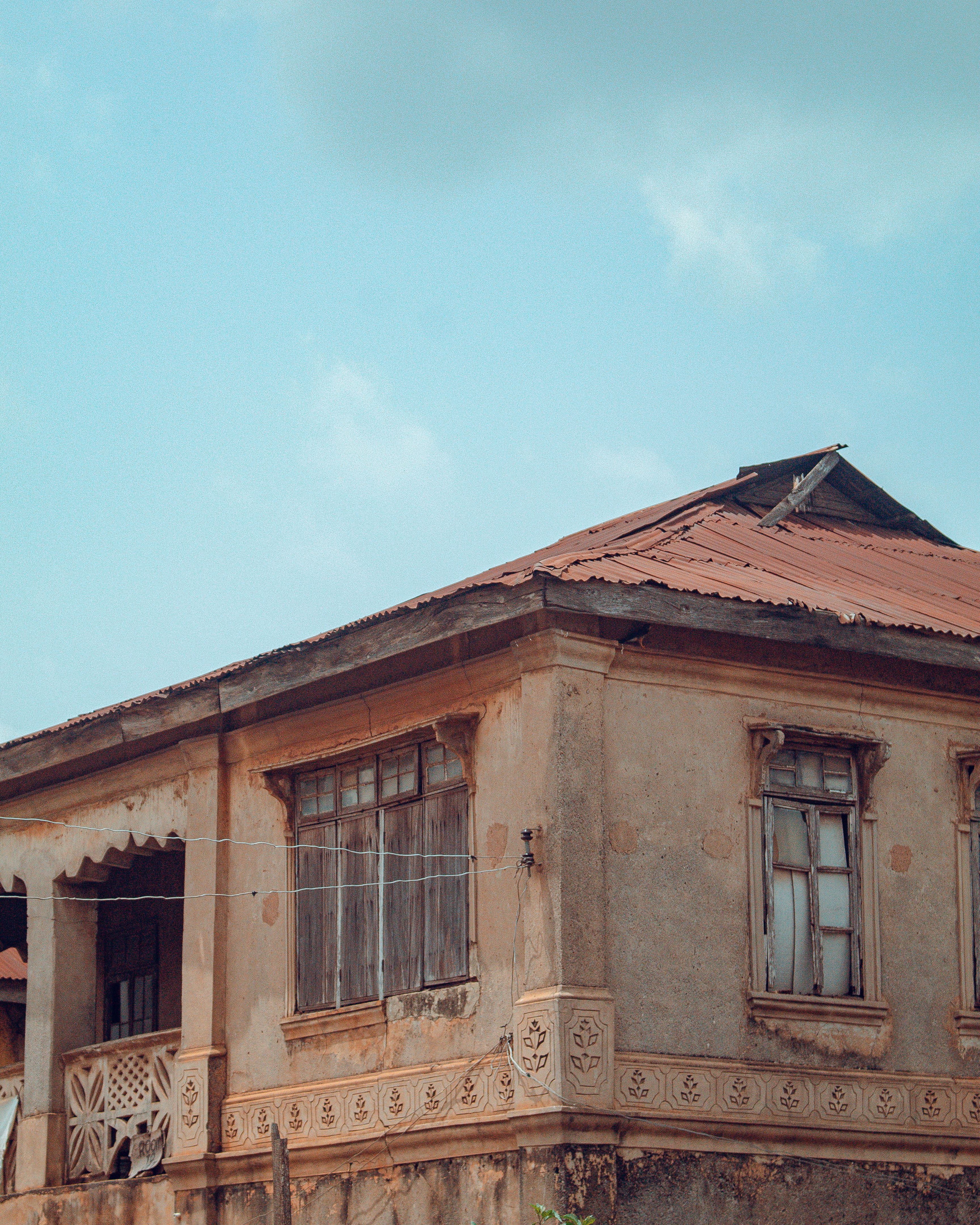 An old building with a red roof and a blue sky · Free Stock Photo