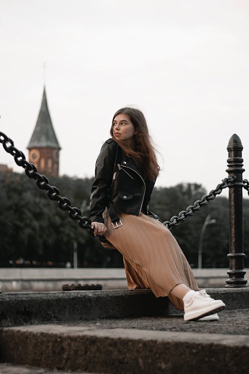 Femme Assise Sur Une Chaîne En Métal