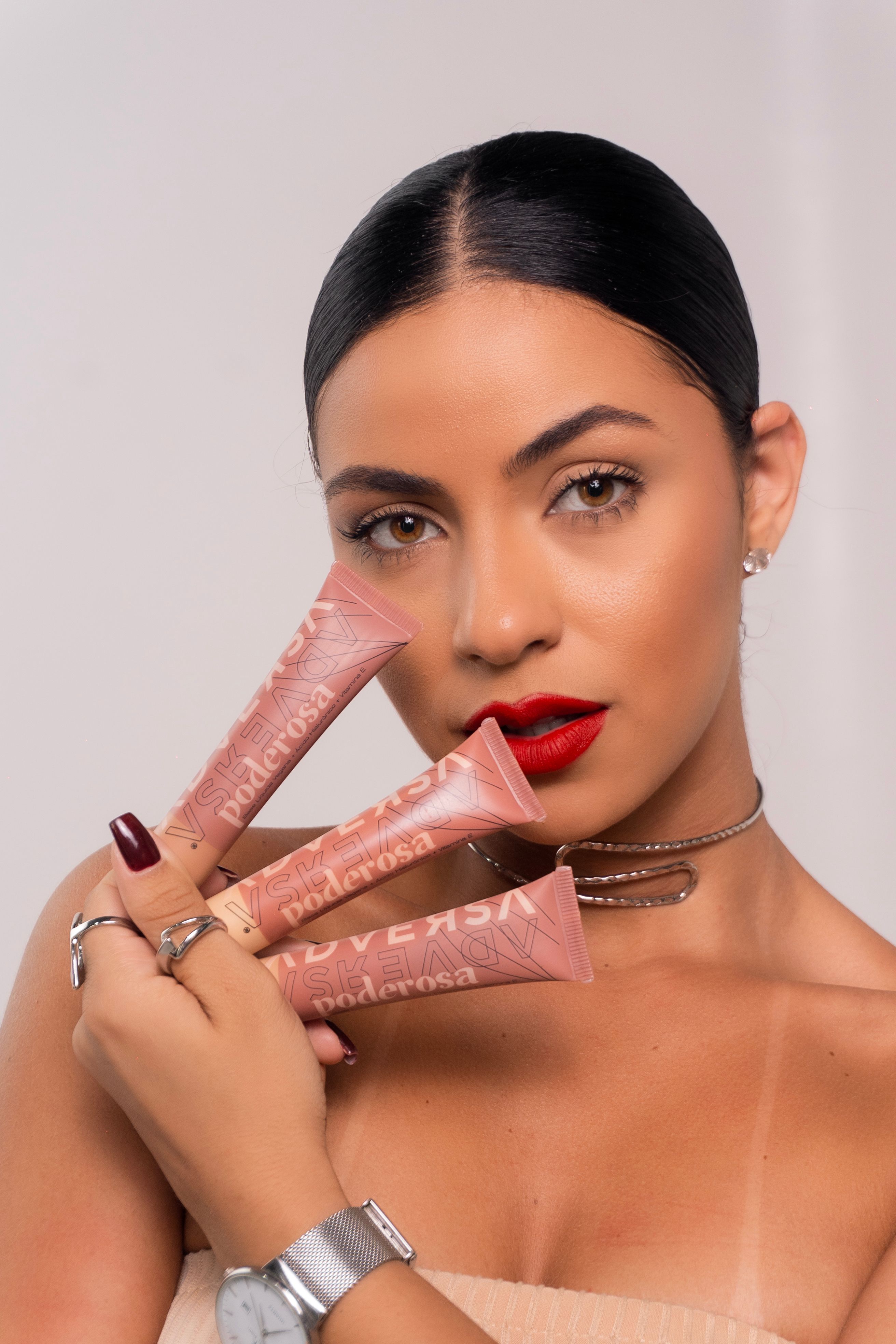 Portrait of a woman showcasing cosmetics with a white background.