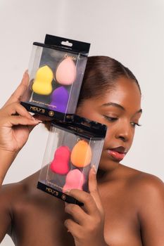 Elegant display of diverse beauty sponges by a young woman.