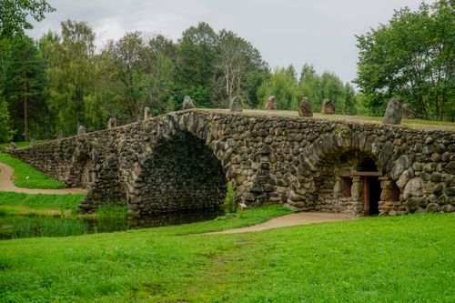 Free Explore the ancient stone bridge in Torzhok, Russia surrounded by lush green parkland. Stock Photo