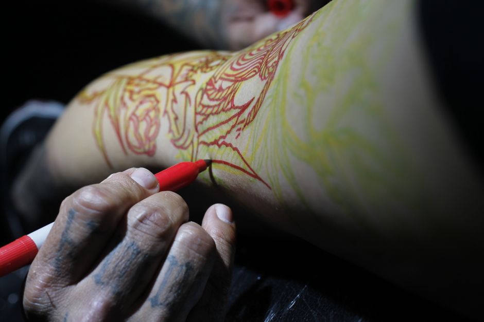 Close-up of a tattoo artist tracing a crisp outline that causes more tattoo outline pain than shading Close-up of a tattoo artist tracing a crisp outline that causes more tattoo outline pain than shading