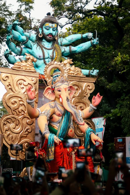 Free A vibrant parade during Ganesh Chaturthi with large Ganesh statue and celebrating crowd. Stock Photo