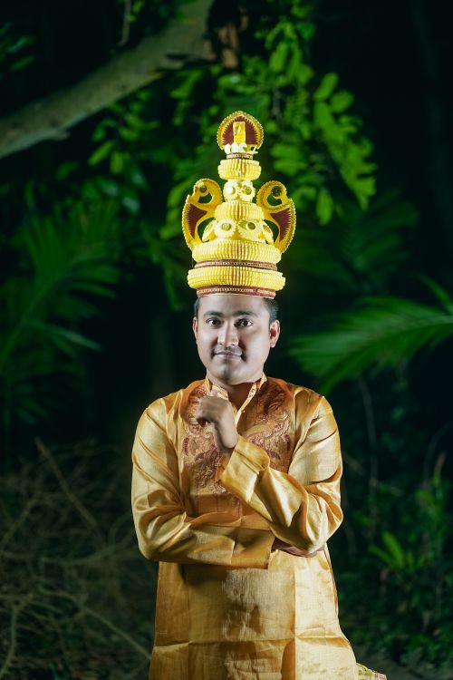 Free A man in traditional clothing and ornate headpiece in an outdoor setting, Bangladesh. Stock Photo