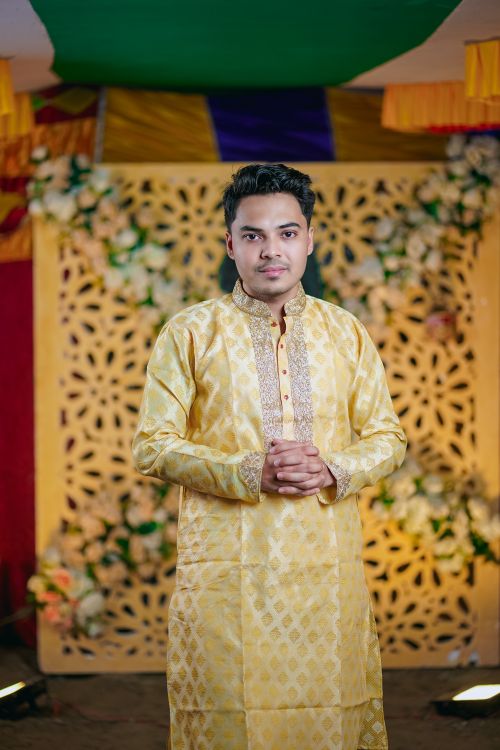 Free Portrait of a man in traditional South Asian wedding attire, indoors with decorative backdrop. Stock Photo