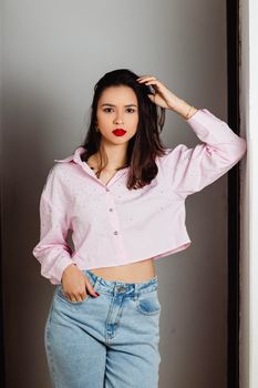 Portrait of a fashionable young woman wearing casual attire indoors.