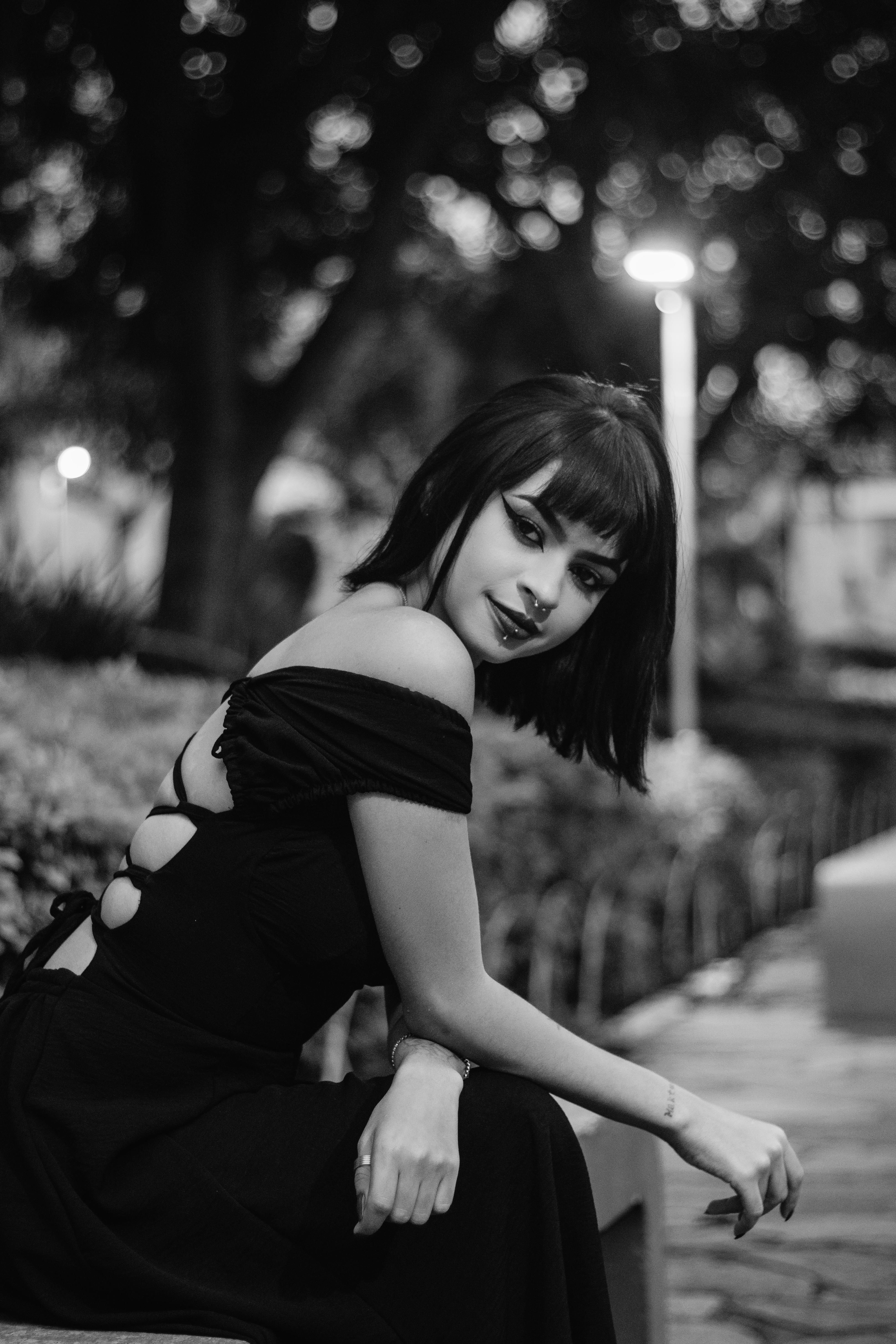 A woman in a black dress sitting on a bench · Free Stock Photo