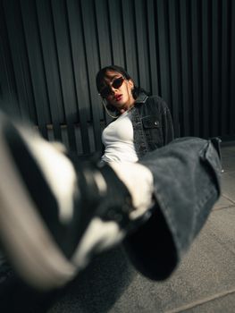 Stylish portrait of a woman in sunglasses and denim in Tehran, exuding modern urban flair.