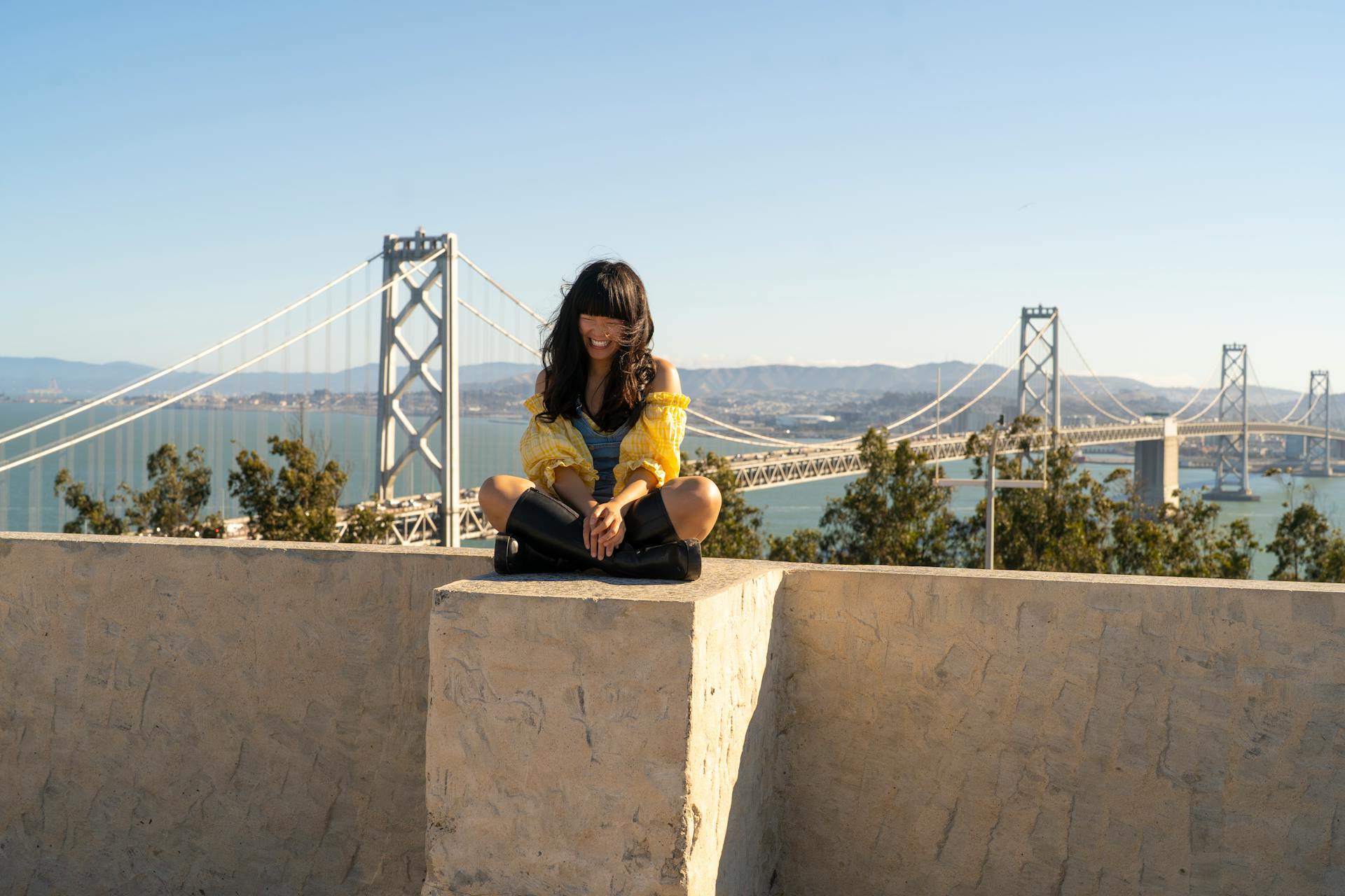 Young Woman Sitting Wall Laughing Oakland Bay Bridge Background