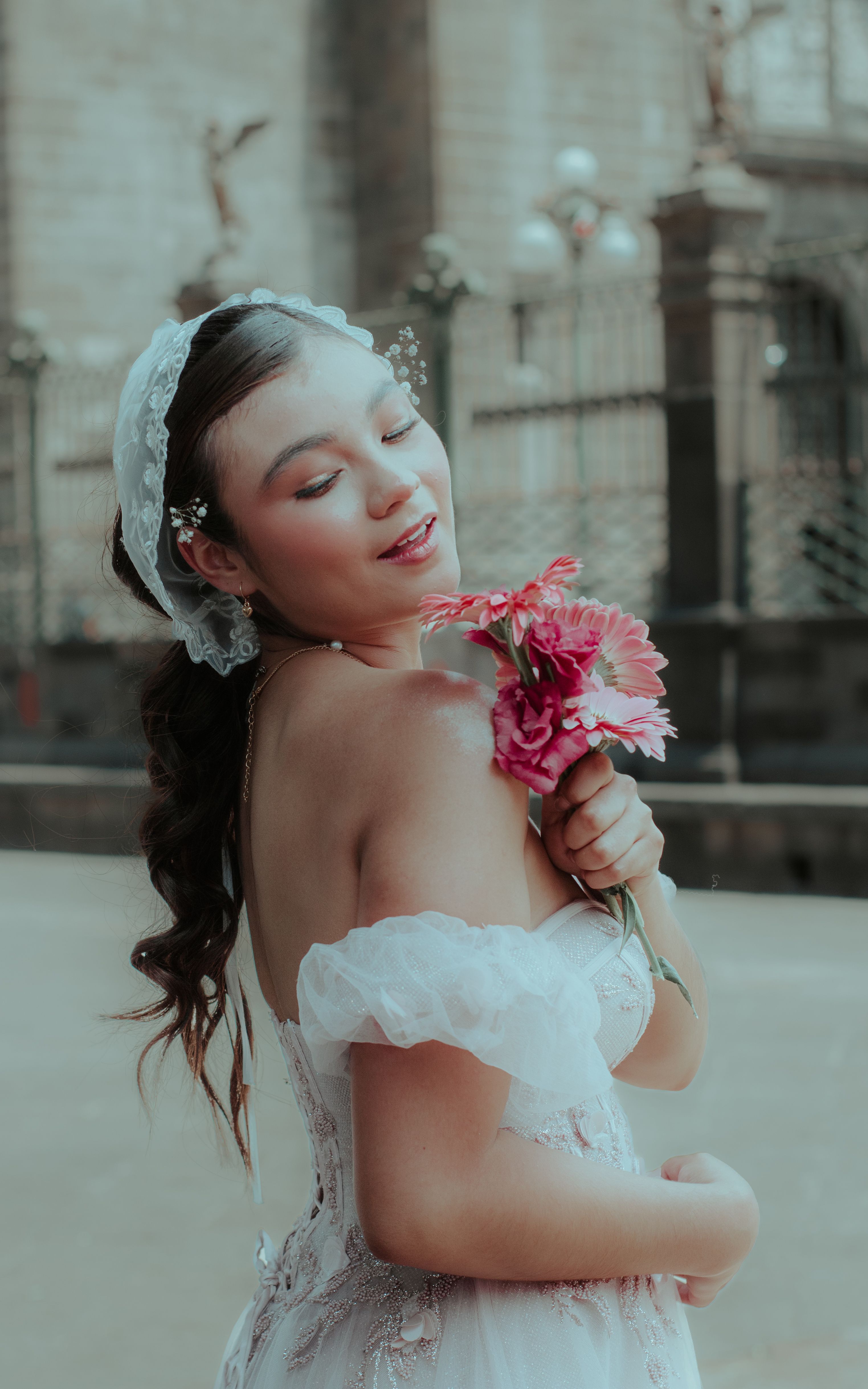 A beautiful bride holding a bouquet of pink flowers, captured elegantly in Puebla, Mexico.