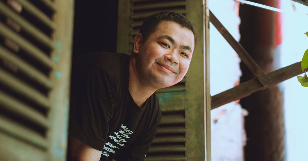 Man Learning Out Window A man smiling while leaning out of a window · Free Stock Photo