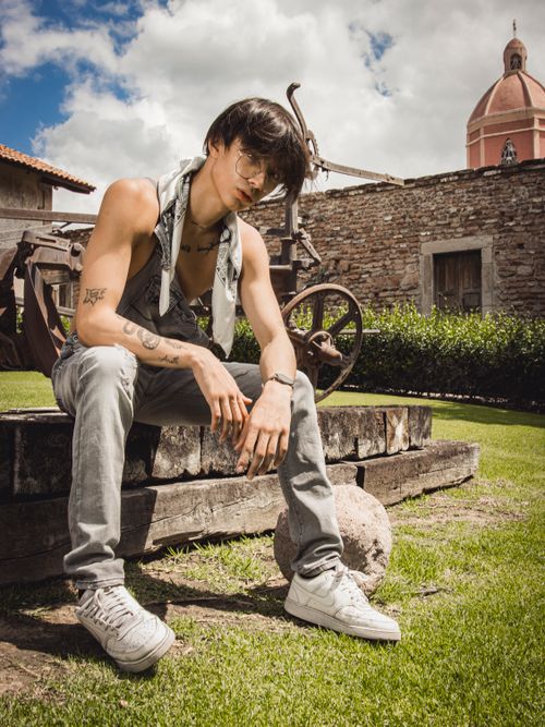 Free Trendy young man posing outdoors in a summer park, showcasing urban fashion. Stock Photo