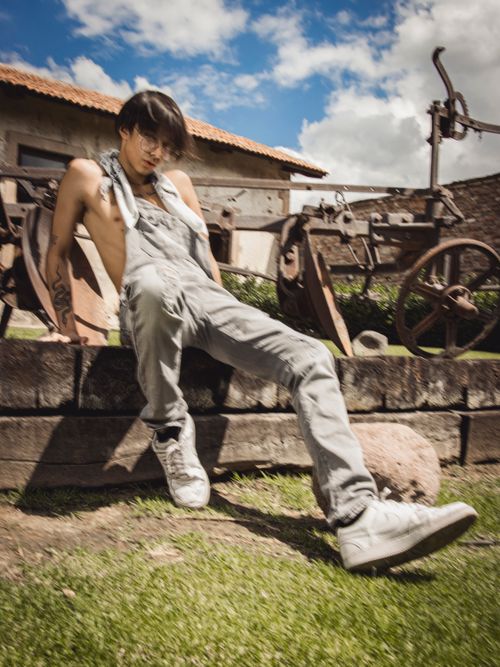 Free Young adult relaxing by vintage machinery in a sunny outdoor scene. Stock Photo