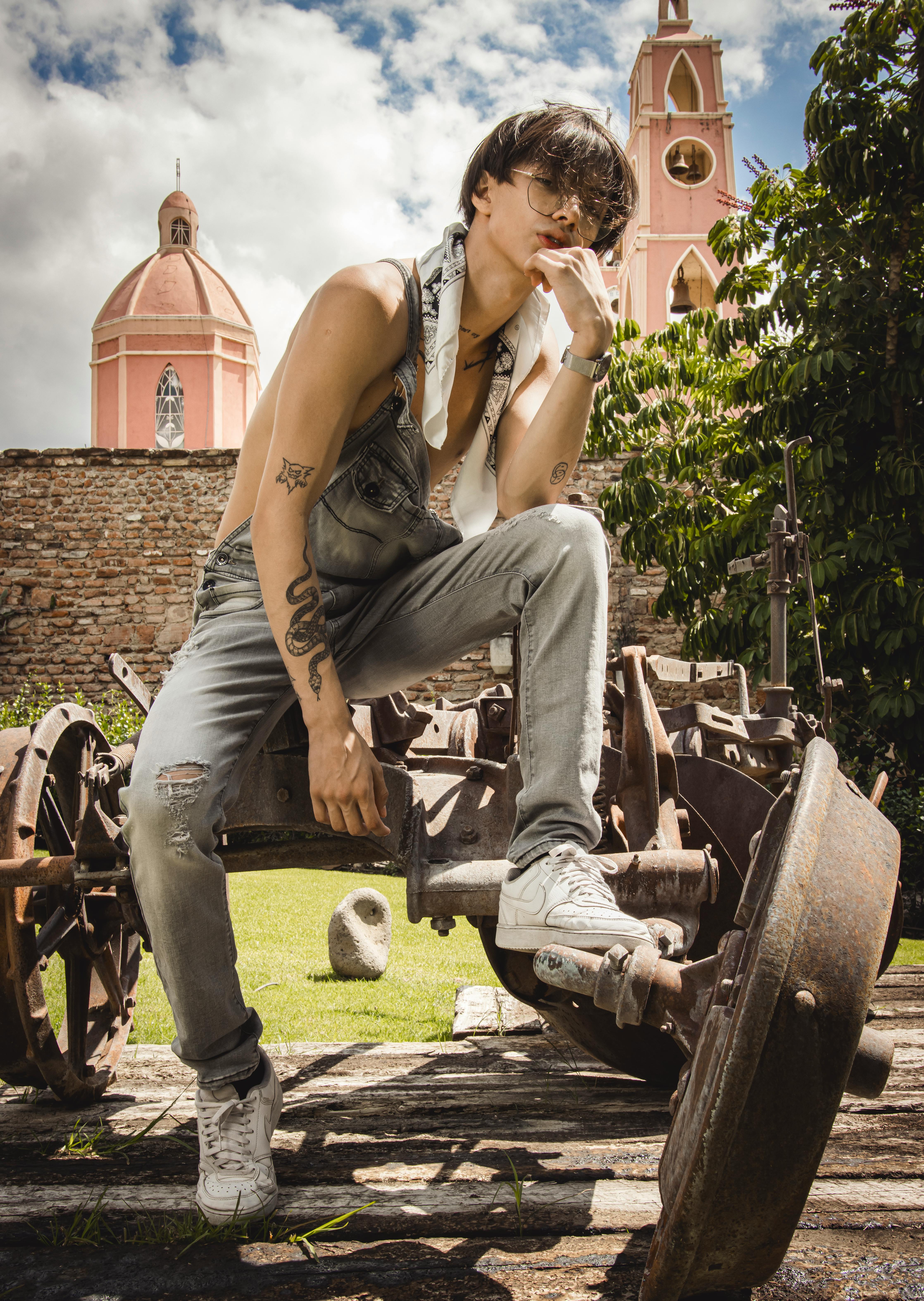 Stylish young man posing confidently amidst urban architecture outdoors.