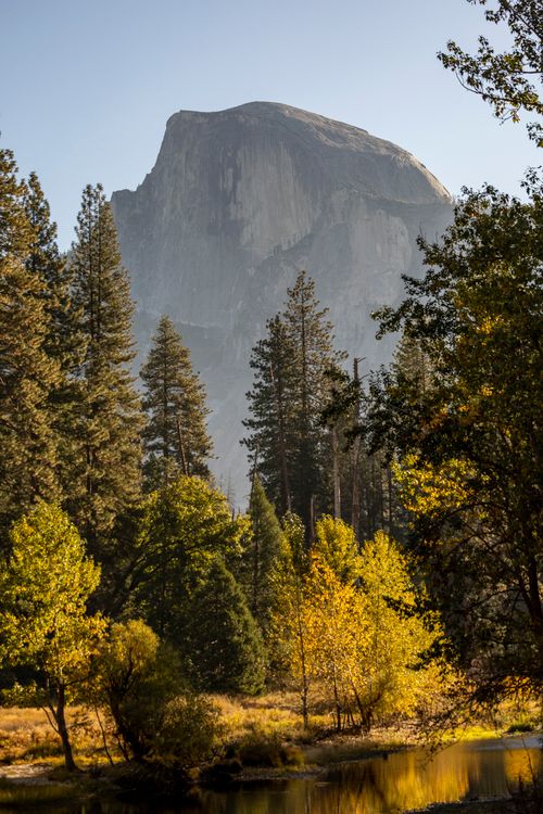 Free Captivating view of Half Dome surrounded by autumn foliage and tranquil water in Yosemite National Park. Stock Photo