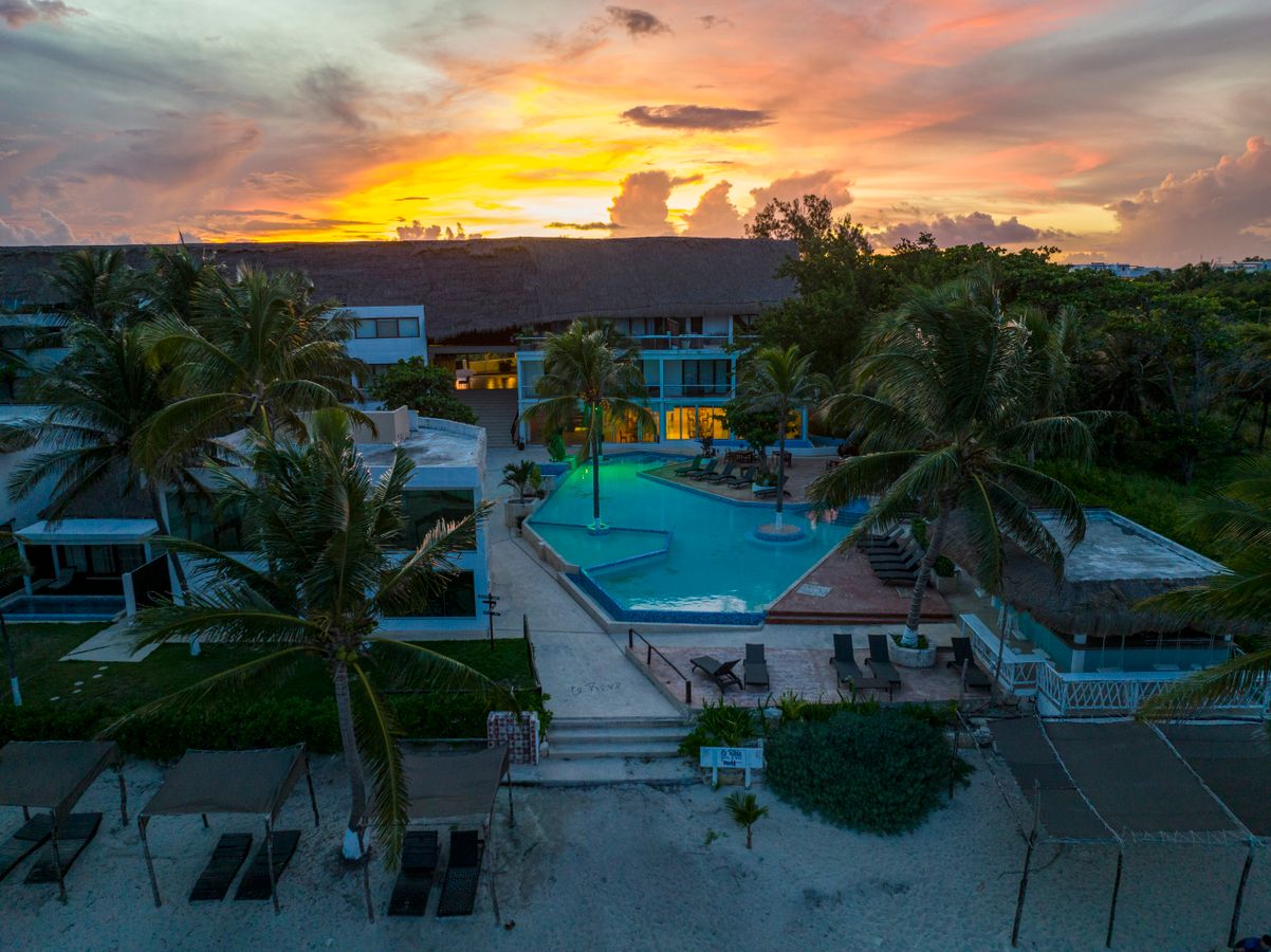 Aerial view of luxury tropical resort with pool at sunset