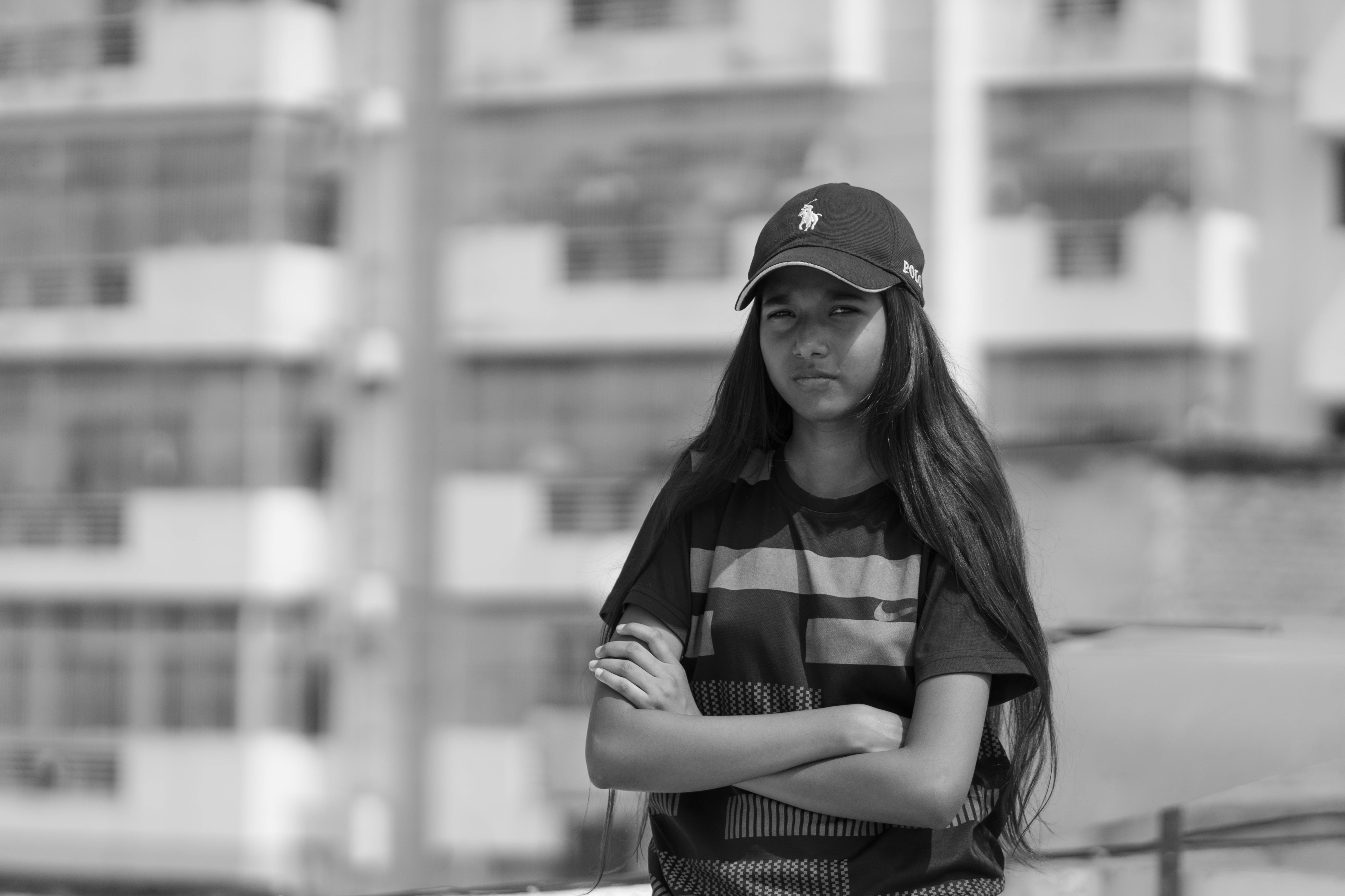 a black and white photo of a girl in a cap