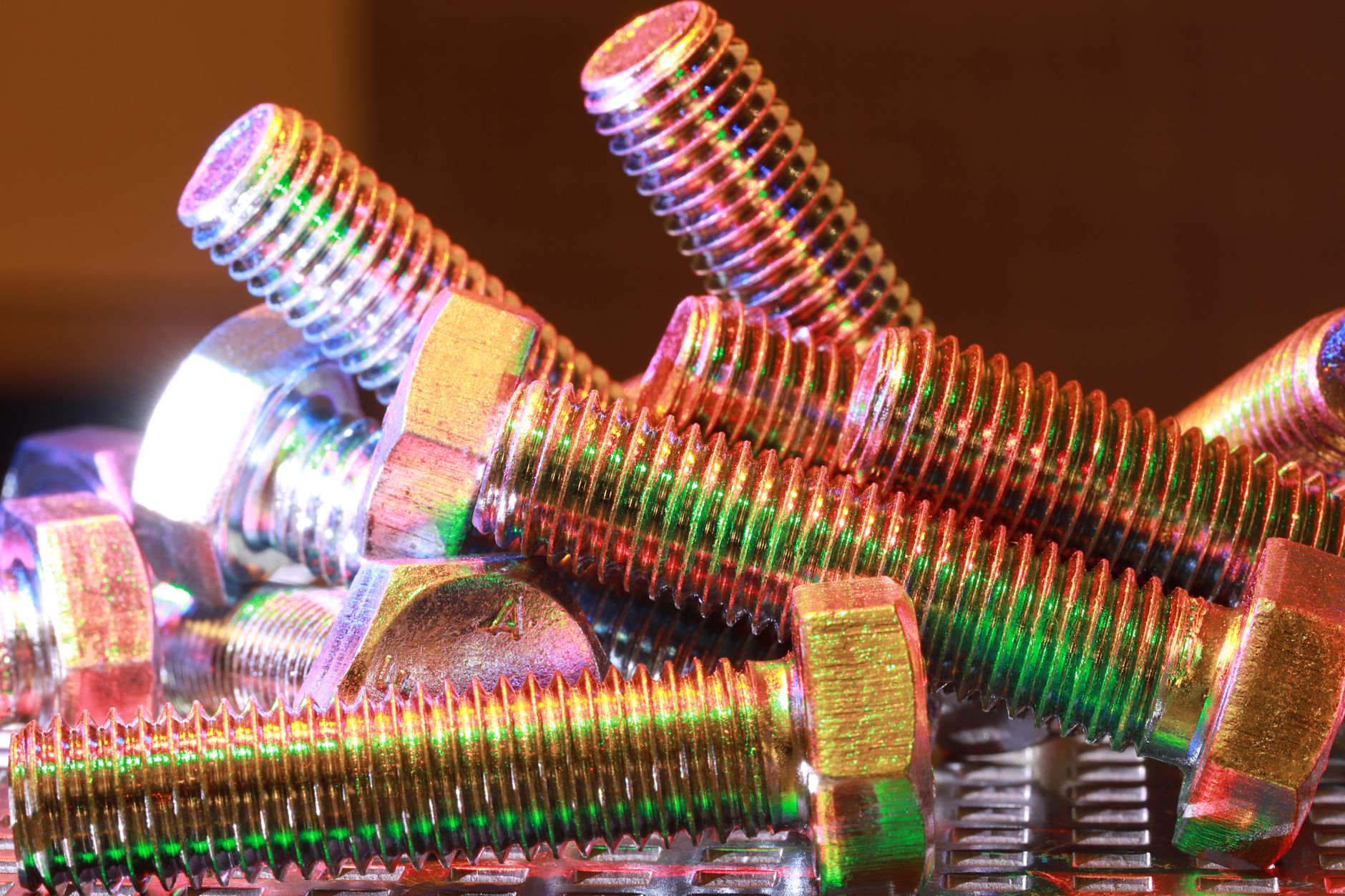 Close-up shot of vibrant, multi-colored metal bolts stacked together, highlighting industrial design.
