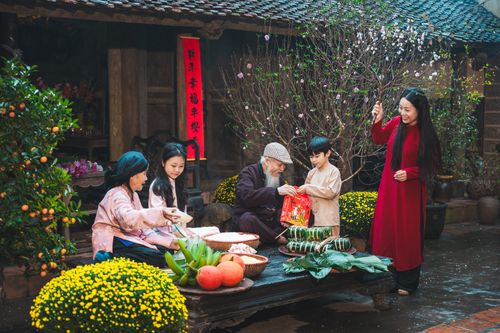 Free Family engaging in traditional Tet New Year celebrations in Hanoi, showcasing cultural traditions. Stock Photo