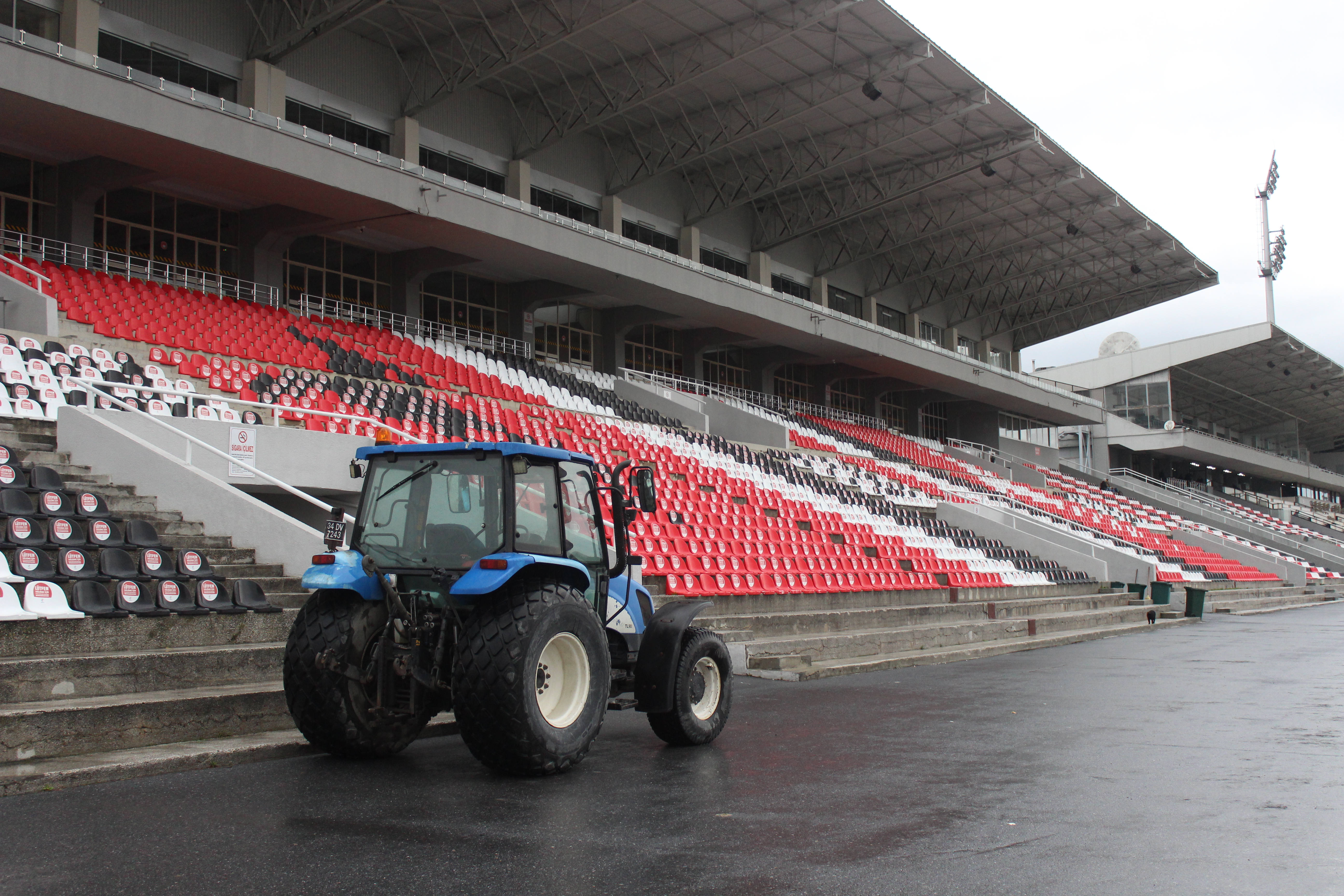 A lone tractor parked inside an empty stadium on a rainy day in Zeytinburnu, İstanbul.