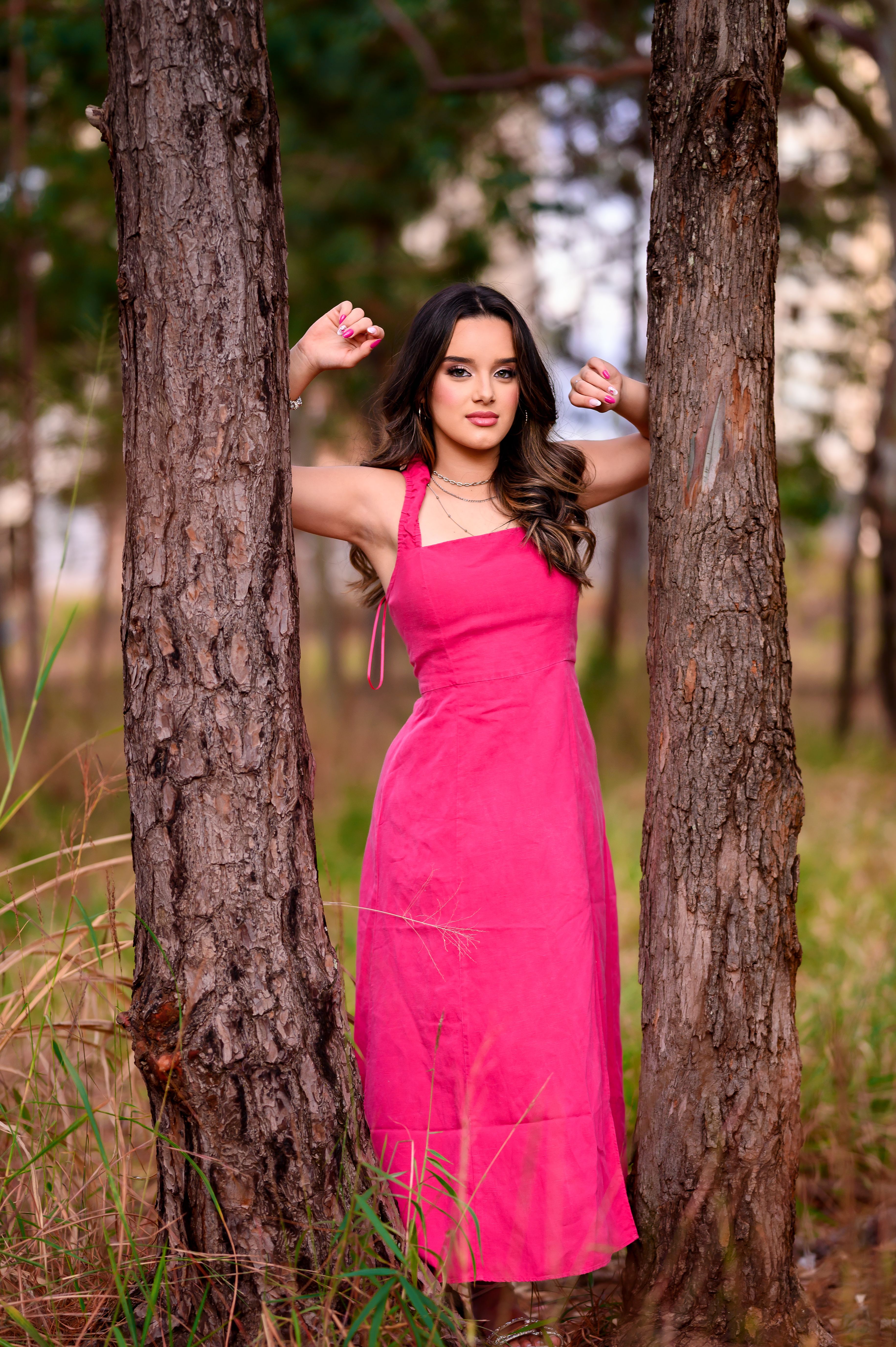 A woman in a pink dress posing in the woods · Free Stock Photo