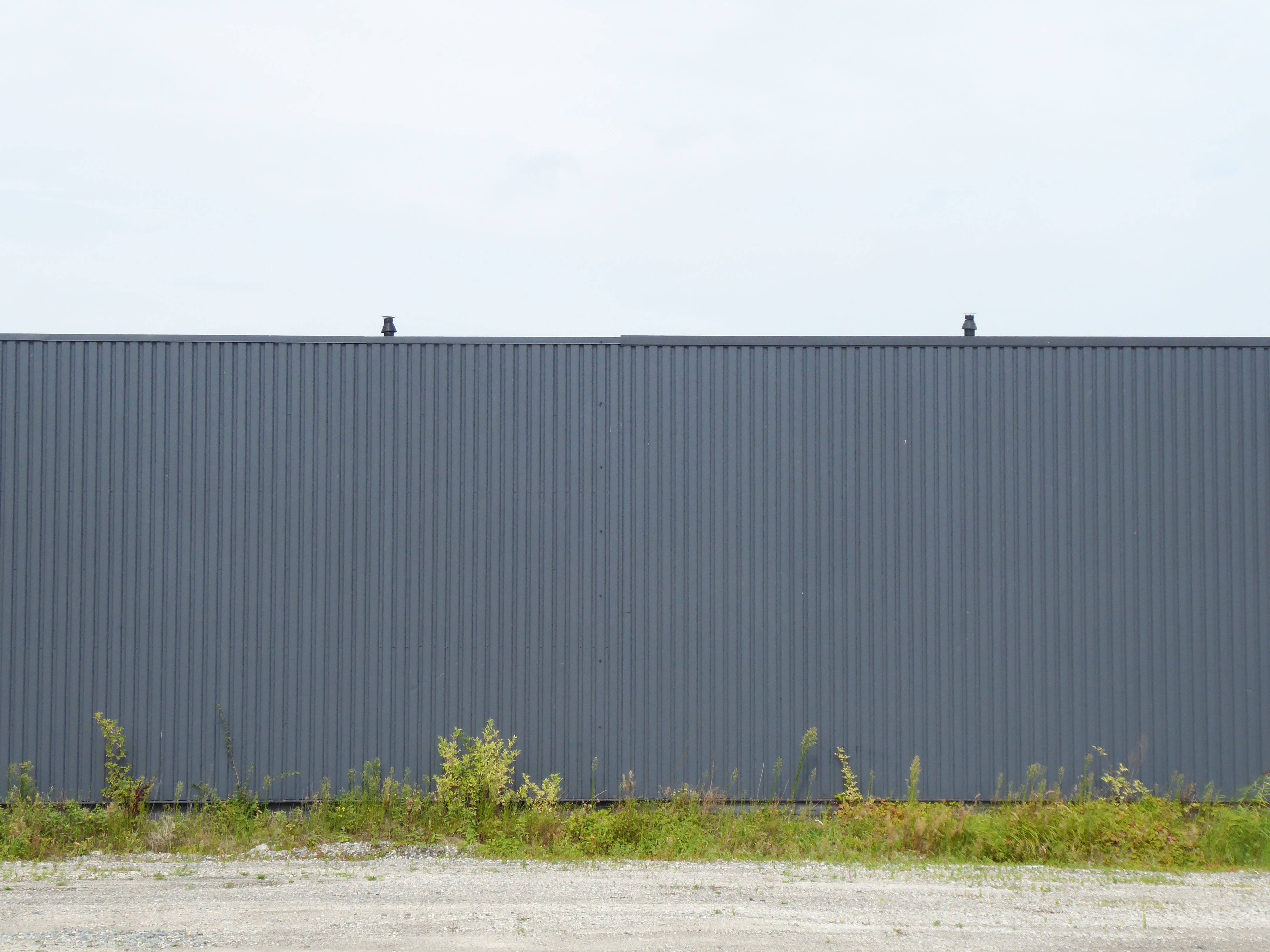 A large gray metal fence with a black roof · Free Stock Photo